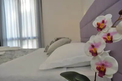 a bed with white sheets and flowers on it at Hotel Sikania in San Vito lo Capo