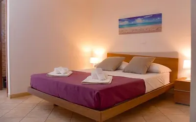a bedroom with a bed with two towels on it at Hotel Sikania in San Vito lo Capo