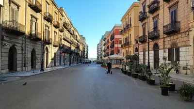a person walking down a street in a city at Palermo Amari in Palermo