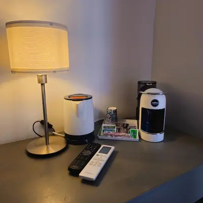 a desk with a lamp and a coffee maker and a remote control at Palermo Amari in Palermo