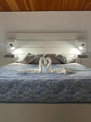 a bed with two swans made to look like hearts at The White Sail - Mondello Apartment with Terrace - casa di vincenzo e andrea in Mondello