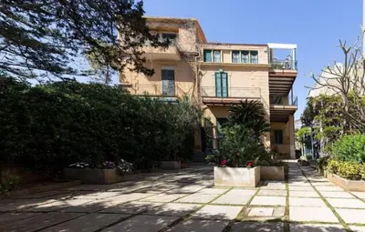a building in front of a building with a courtyard at The White Sail - Mondello Apartment with Terrace - casa di vincenzo e andrea in Mondello