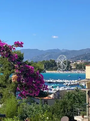 a view of a beach with a ferris wheel in the background at The White Sail - Mondello Apartment with Terrace - casa di vincenzo e andrea in Mondello