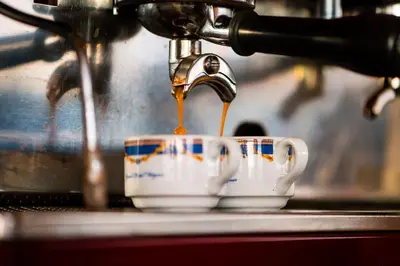 a coffee maker is pouring coffee into two cups at Grand Hotel Wagner in Palermo