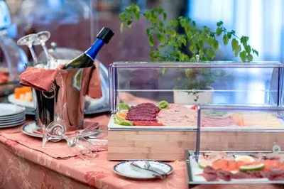 a table with a bottle of wine and a tray of food at Grand Hotel Wagner in Palermo