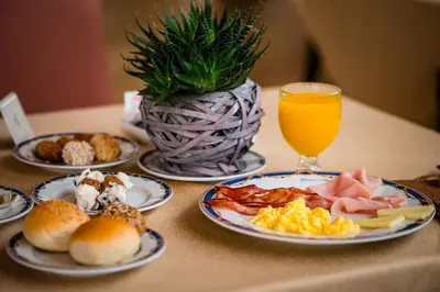 a table with plates of food and a glass of orange juice at Grand Hotel Wagner in Palermo