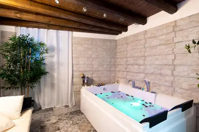 a bathtub with a blue water inside of it at Principe di villafranca Suite in Palermo
