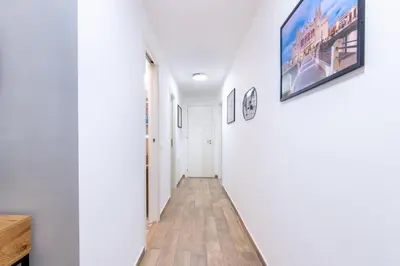 a hallway with white walls and a tv on a wall at Principe di villafranca Suite in Palermo