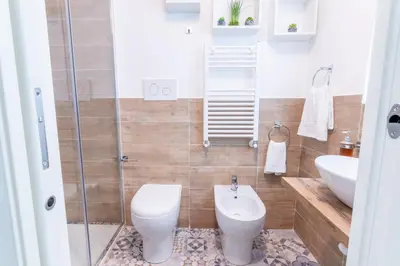 a bathroom with a toilet and a sink and a shower at Principe di villafranca Suite in Palermo