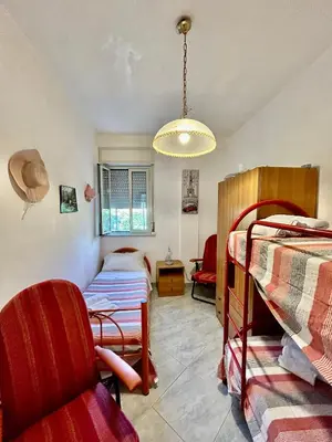 a bedroom with two bunk beds and a chair at Aromi di Sicilia Casa Vacanze in Palermo