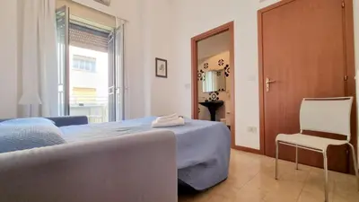 a bedroom with a bed and a chair and a mirror at Molo Santa Lucia 248 in Palermo
