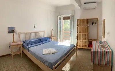 a bedroom with a large bed with blue sheets and blue pillows at Like Home Calamazzo di Sciacca in Scopello