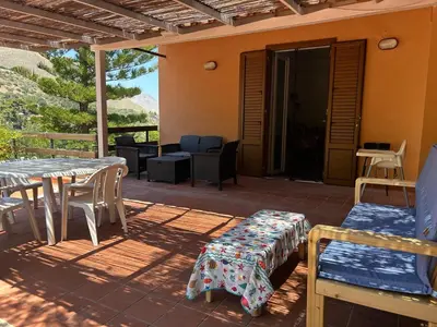 a patio with a table and chairs on a patio at Like Home Calamazzo di Sciacca in Scopello