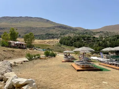 a group of chairs and umbrellas in a field at Like Home Calamazzo di Sciacca in Scopello