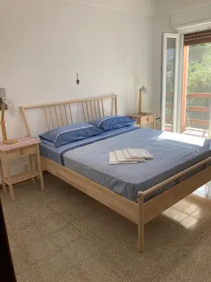 a bedroom with a large bed with a blue blanket at Like Home Calamazzo di Sciacca in Scopello