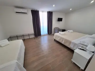 a bedroom with two beds and a wooden floor at Domus Levante in Terrasini