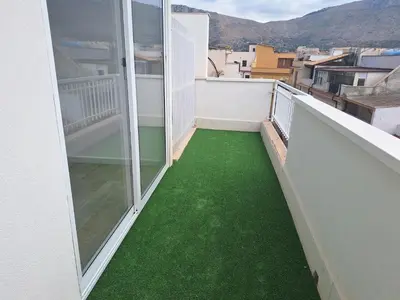 a balcony with green flooring on a building at Domus Levante in Terrasini
