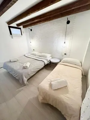two beds in a room with white walls at Casa Myrtos in Palermo