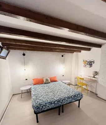 a bedroom with a bed and two chairs and a table at Casa Myrtos in Palermo