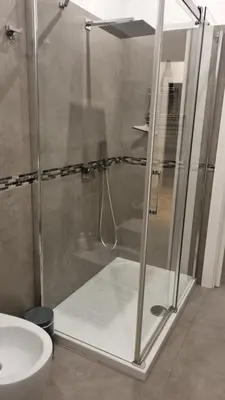 a shower with a glass door in a bathroom at Dudi Apartment in Palermo