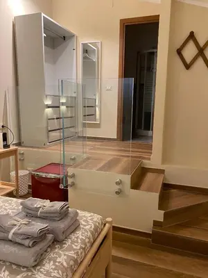 a bathroom with a glass shower and stairs with towels at Chirone Room in Mondello