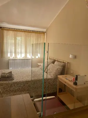 a bedroom with a bed and a table and a glass door at Chirone Room in Mondello
