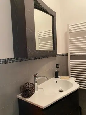 a bathroom with a white sink and a mirror at Chirone Room in Mondello