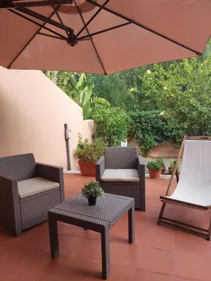 a patio with two chairs and an umbrella at Chirone Room in Mondello