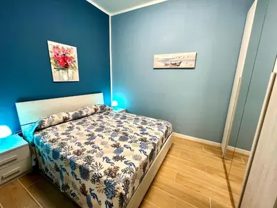 a small bedroom with a bed and blue walls at Casa del Pescatore in Isola delle Femmine