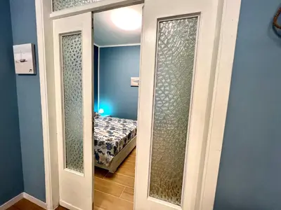 a door leading to a bedroom with a bed at Casa del Pescatore in Isola delle Femmine