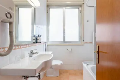 a bathroom with a sink and a toilet and windows at Crisol Europa in Palermo