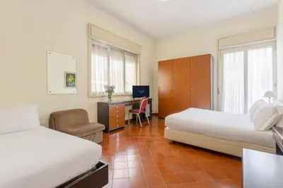 a hotel room with two beds and a desk at Crisol Europa in Palermo
