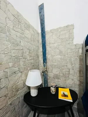 a table with a lamp and a book next to a stone wall at Covo del pescatore in Bagheria