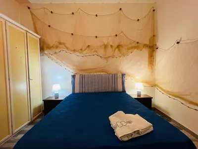a bedroom with a blue bed with two towels on it at Covo del pescatore in Bagheria
