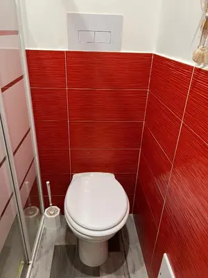 a bathroom with a white toilet in a red wall at Covo del pescatore in Bagheria