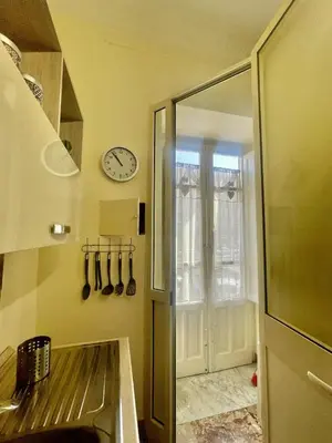 a kitchen with a sink and a clock on the wall at Maya's Apartment close to Ballarò Market and Central station in Palermo