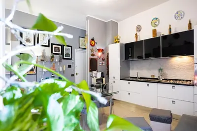a living room with a kitchen with white cabinets at Hola Cathedral House Porta di Castro in Palermo