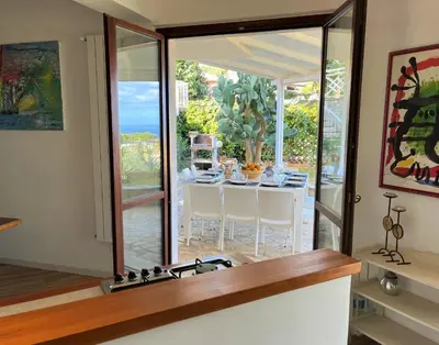 a dining room with a table and a glass door at Villa Mediterraneo in Altavilla Milicia
