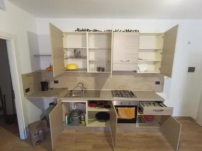 a small kitchen with white cabinets and a sink at MC Rooms in Torretta