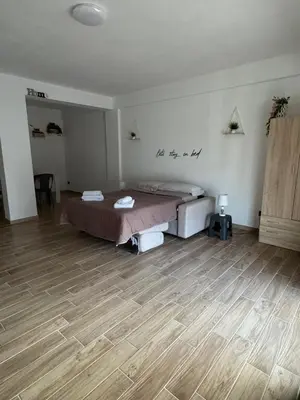 a bedroom with a bed and a wooden floor at MC Rooms in Torretta