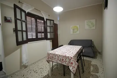 a room with a table and a chair and a window at Casa chrilù in Palermo