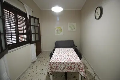 a room with a table and a clock on the wall at Casa chrilù in Palermo