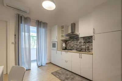 a kitchen with white cabinets and a large window at Al Khalisa Apartment by Wonderful Italy in Palermo