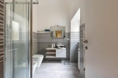 a bathroom with a toilet and a sink and a mirror at Al Khalisa Apartment by Wonderful Italy in Palermo