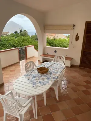 a table and chairs in a room with a view at Villa San Vito Bay in Macari