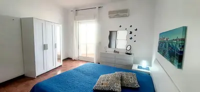 a bedroom with a blue bed and a mirror at Dune Dorate,Tramonti Infiniti la tua oasi di pace in Dune ! Aprile al Mare in Appartamento con vista panoramica e WiFi Casa Vacanza Vista Mare in Sicilia Relax e Tramonti Unici in Alcamo Marina
