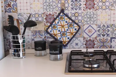 a kitchen counter with a stove and a tile wall at Dune Dorate,Tramonti Infiniti la tua oasi di pace in Dune ! Aprile al Mare in Appartamento con vista panoramica e WiFi Casa Vacanza Vista Mare in Sicilia Relax e Tramonti Unici in Alcamo Marina