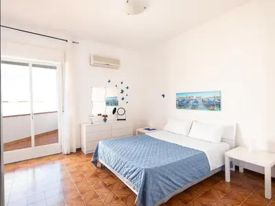 a white bedroom with a bed and a window at Dune Dorate,Tramonti Infiniti la tua oasi di pace in Dune ! Aprile al Mare in Appartamento con vista panoramica e WiFi Casa Vacanza Vista Mare in Sicilia Relax e Tramonti Unici in Alcamo Marina