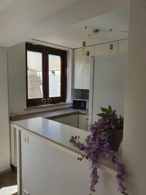 a kitchen with a white counter and a window at Dancing Apartment in Castelluzzo