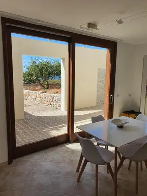 a dining room with a table and a glass door at Dancing Apartment in Castelluzzo
